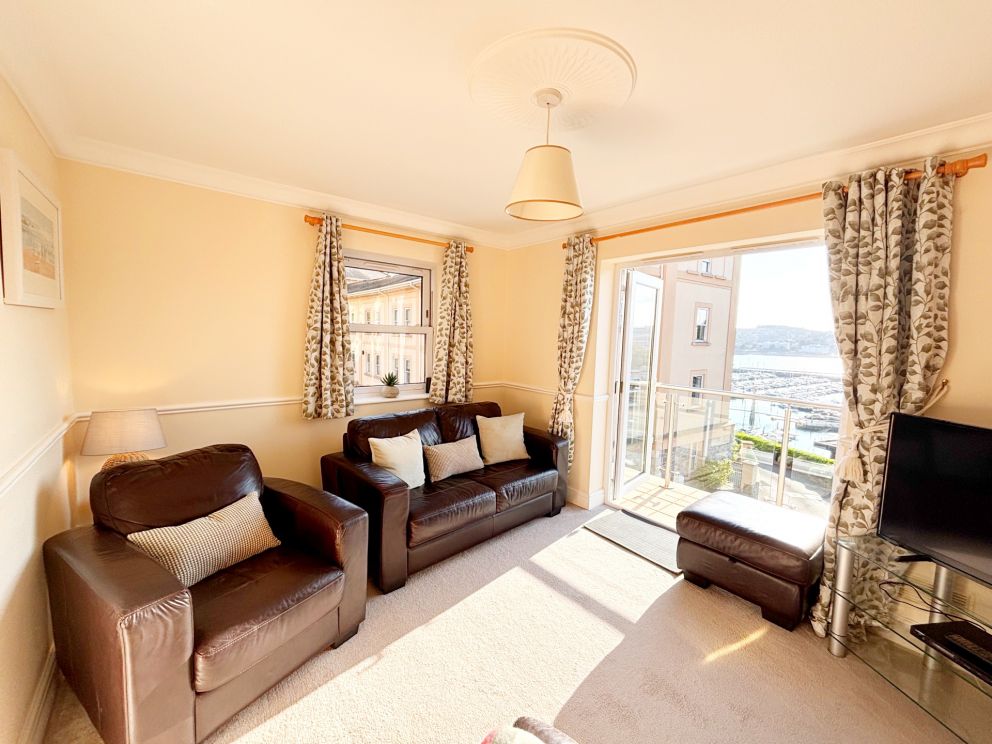 2, The Riviera, Torquay. First floor living room with French doors onto a balcony.